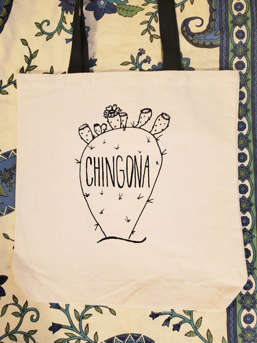 A beige tote bag that has the image of a cactus on it and small blossoms. The words 